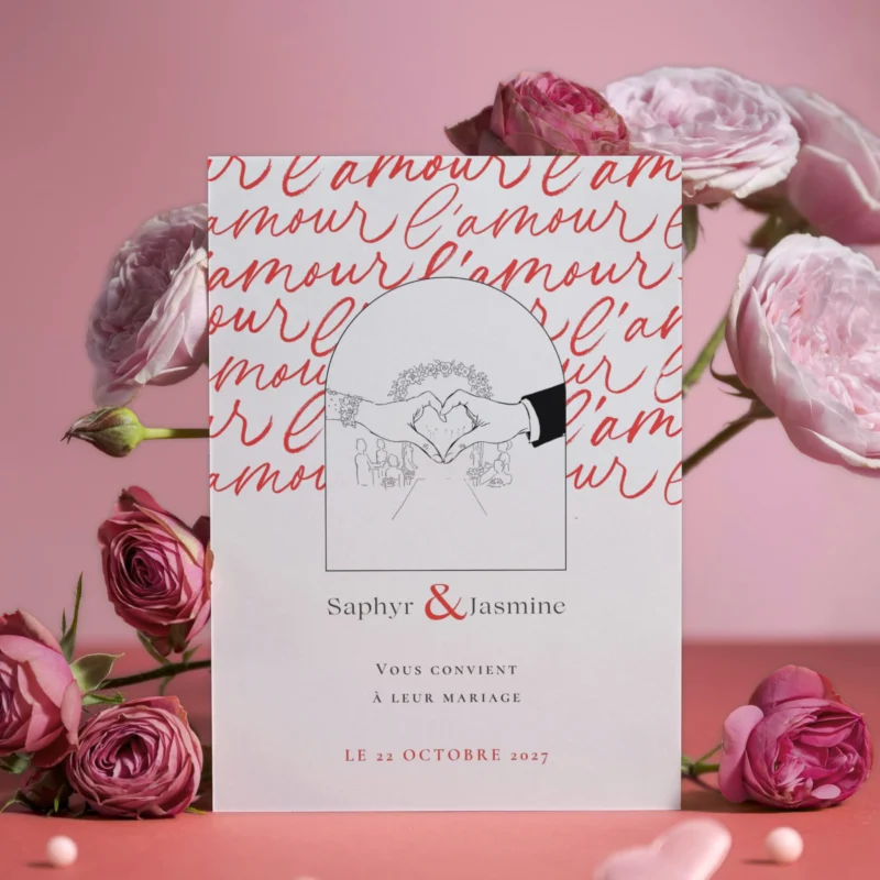 Faire-part de mariage L’amour — carte illustrée de deux mains formant un cœur sur un fond rouge où le mot “l’amour” est répété en calligraphie, modèle M&Heaven.